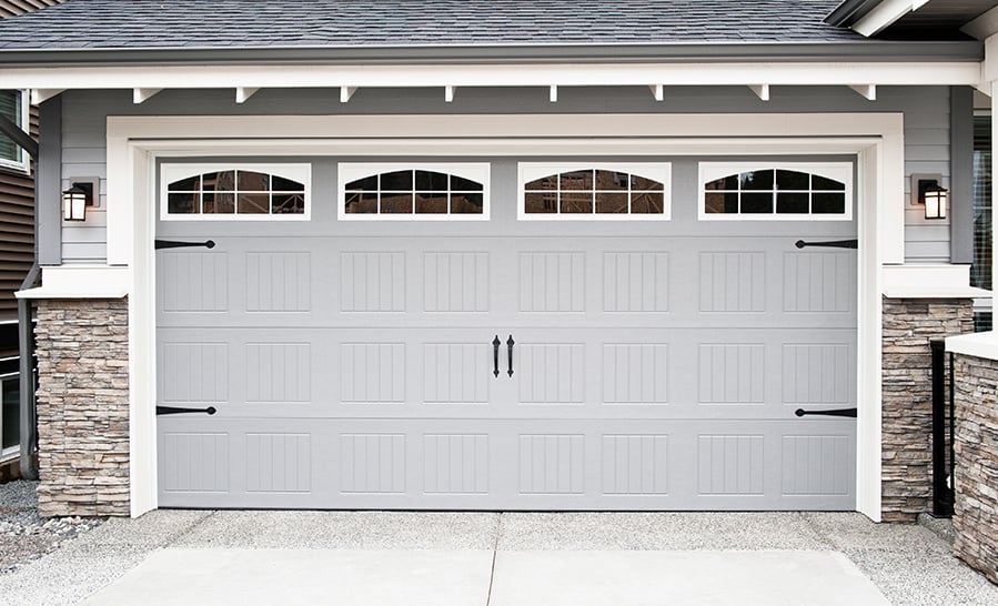 Black craftsman entry door with sidelights and a transom in a stone-and-shingle entry