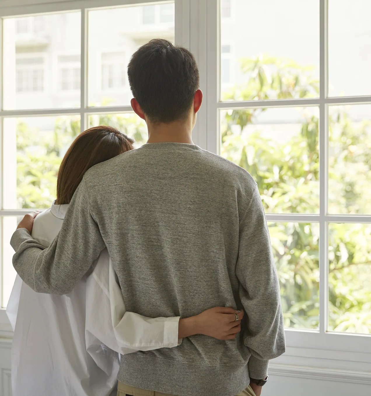 Couple looking out through a new Castle Windows double-hung window