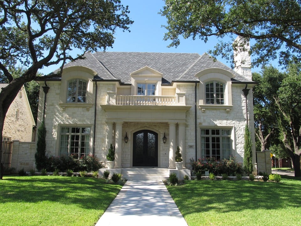 A large elegant mansion with manicured gardens and a grand facade