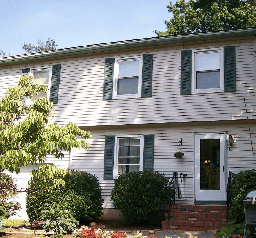 tan home with oriel windows and dark shutters