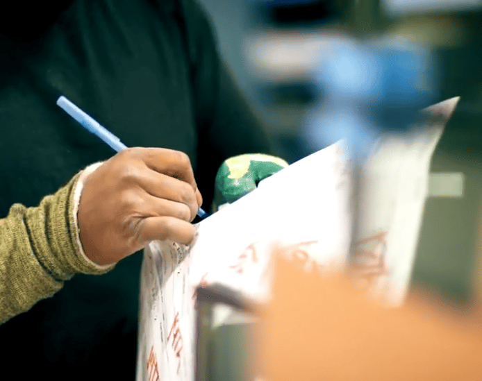 man writing on document